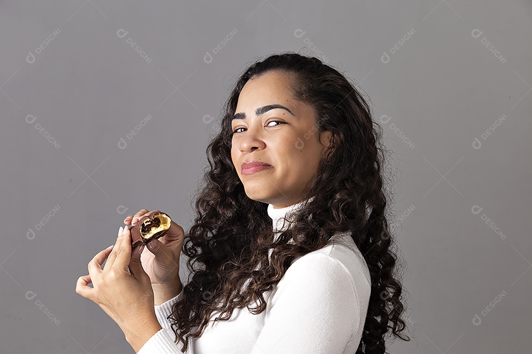 Linda mulher comendo chocolate sobre fundo isolado