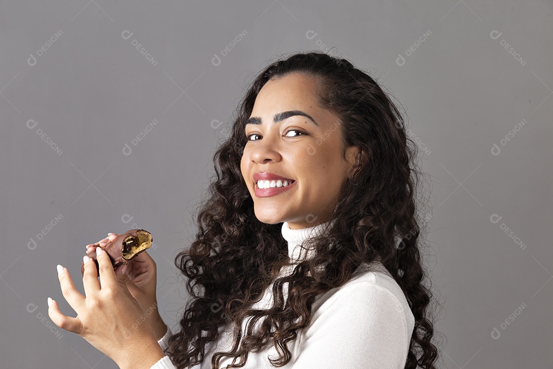 Linda mulher comendo chocolate sobre fundo isolado
