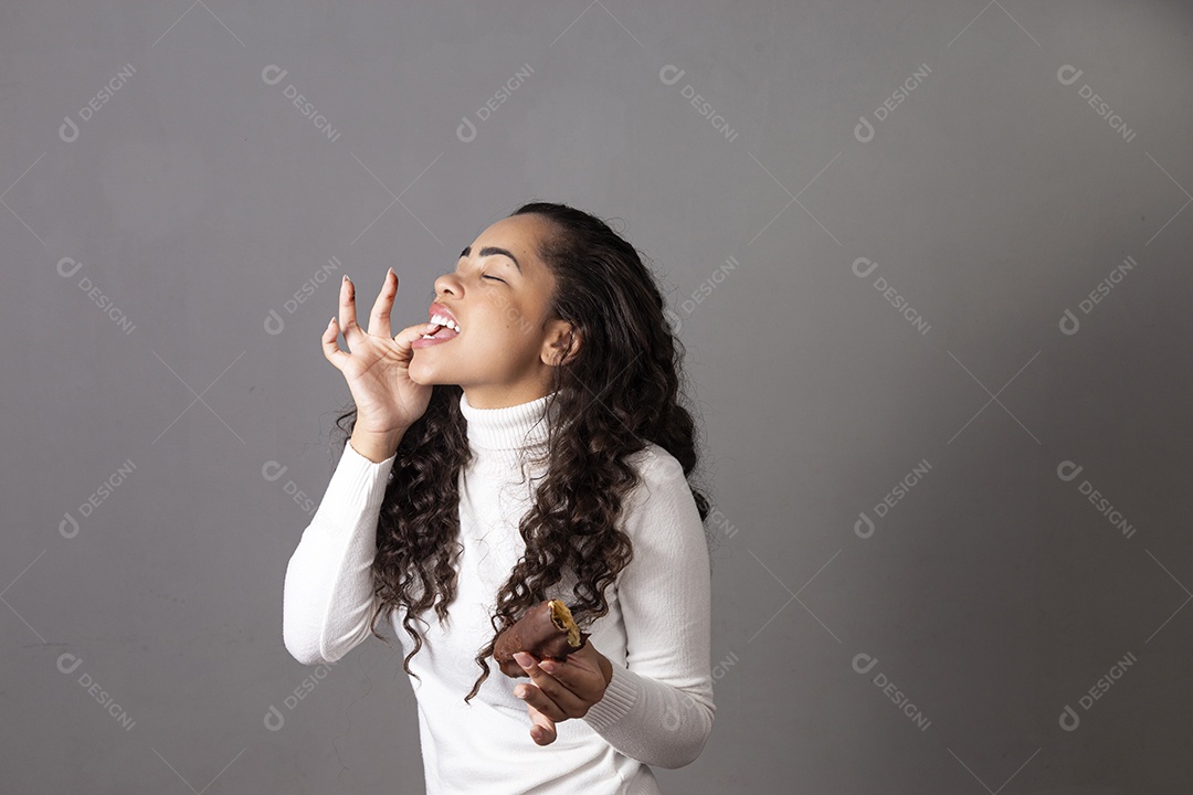 Linda mulher comendo chocolate sobre fundo isolado