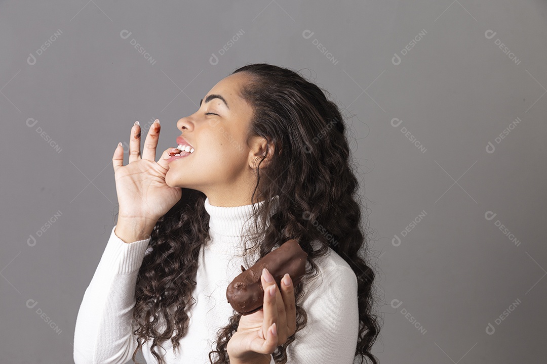 Linda mulher comendo chocolate sobre fundo isolado
