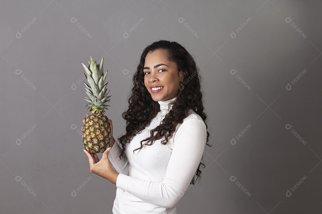 Linda mulher segurando abacaxi sobre fundo isolado