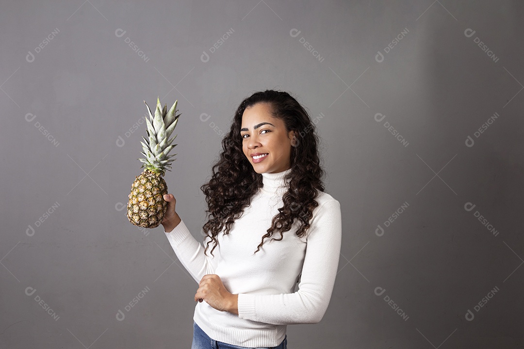 Linda mulher segurando abacaxi sobre fundo isolado