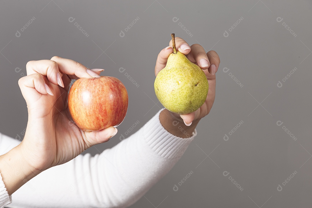 Mãos femininas segurando frutas sobre fundo isolado