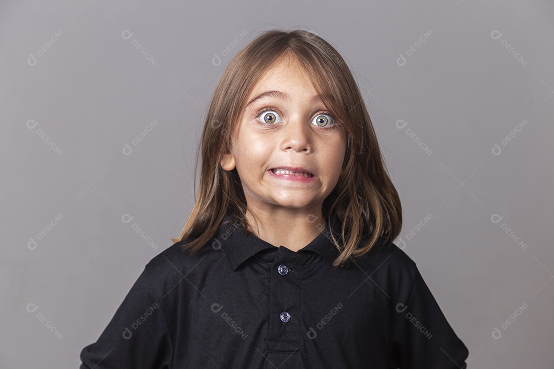 Criança com expressão facial assustada sobre fundo isolado