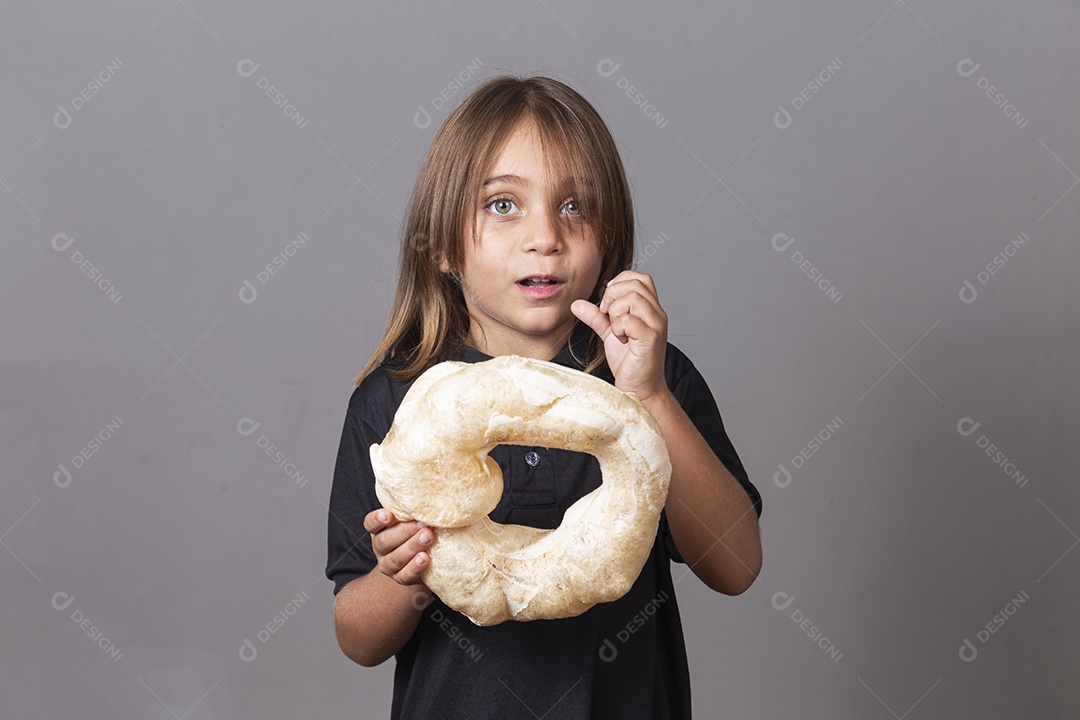 Criança segurando biscoito rosca de polvilho sobre fundo isolado