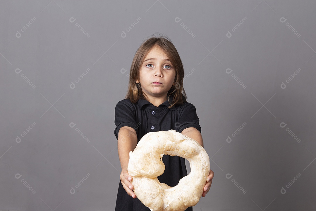 Criança segurando biscoito rosca de polvilho sobre fundo isolado