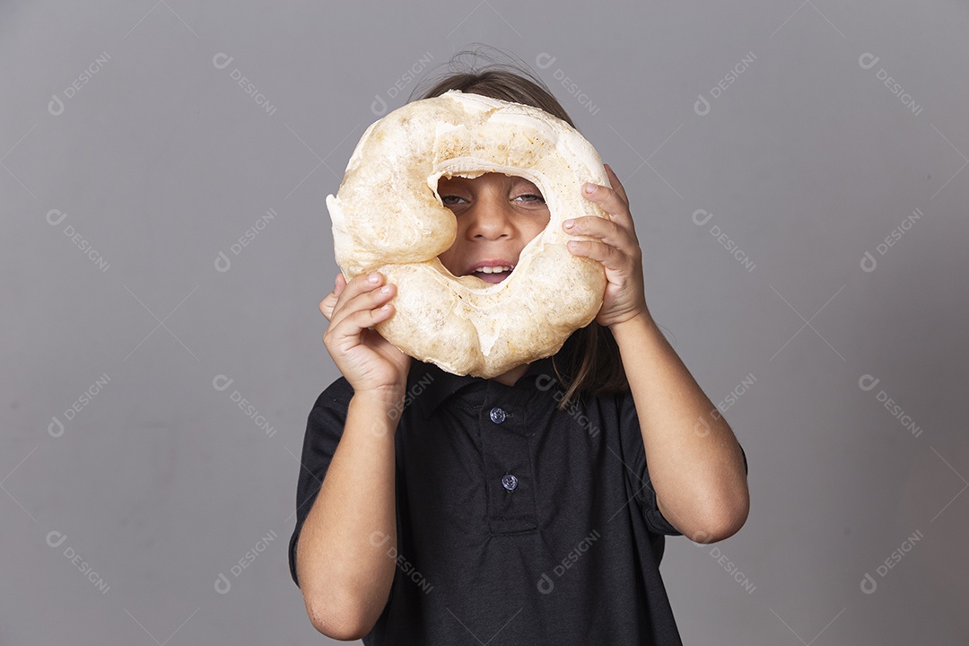 Criança segurando biscoito rosca de polvilho sobre fundo isolado