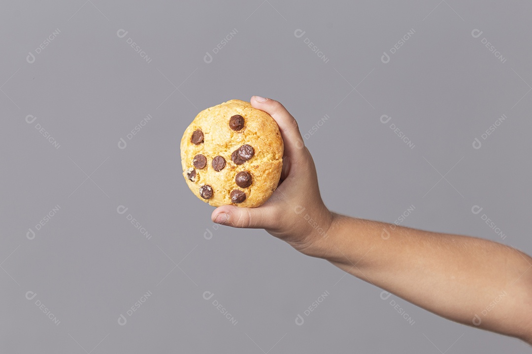 Mão segurando cookie sobre fundo isolado