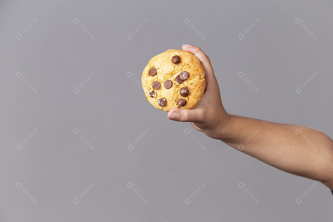 Mão segurando cookie sobre fundo isolado