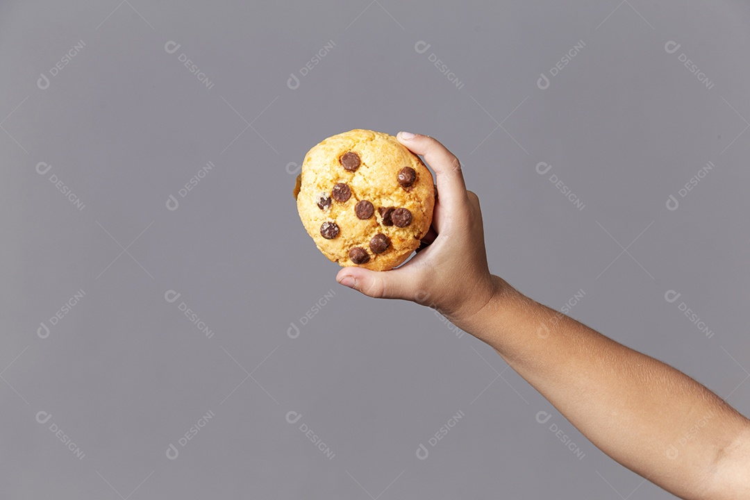 Mão segurando cookie sobre fundo isolado