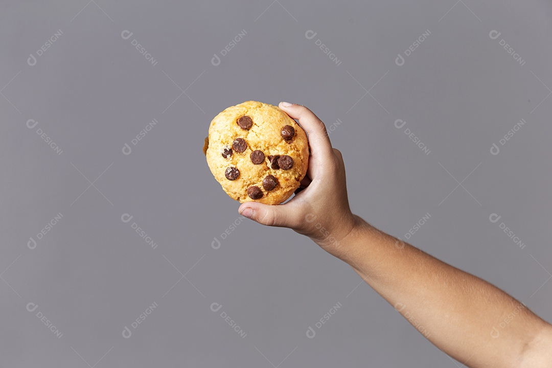 Mão segurando cookie sobre fundo isolado