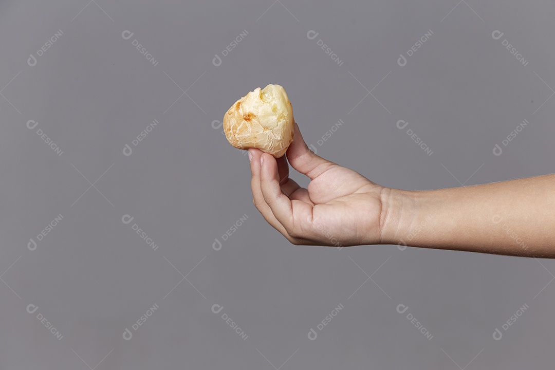 Mão segurando pão de quiejo sobre fundo isolado