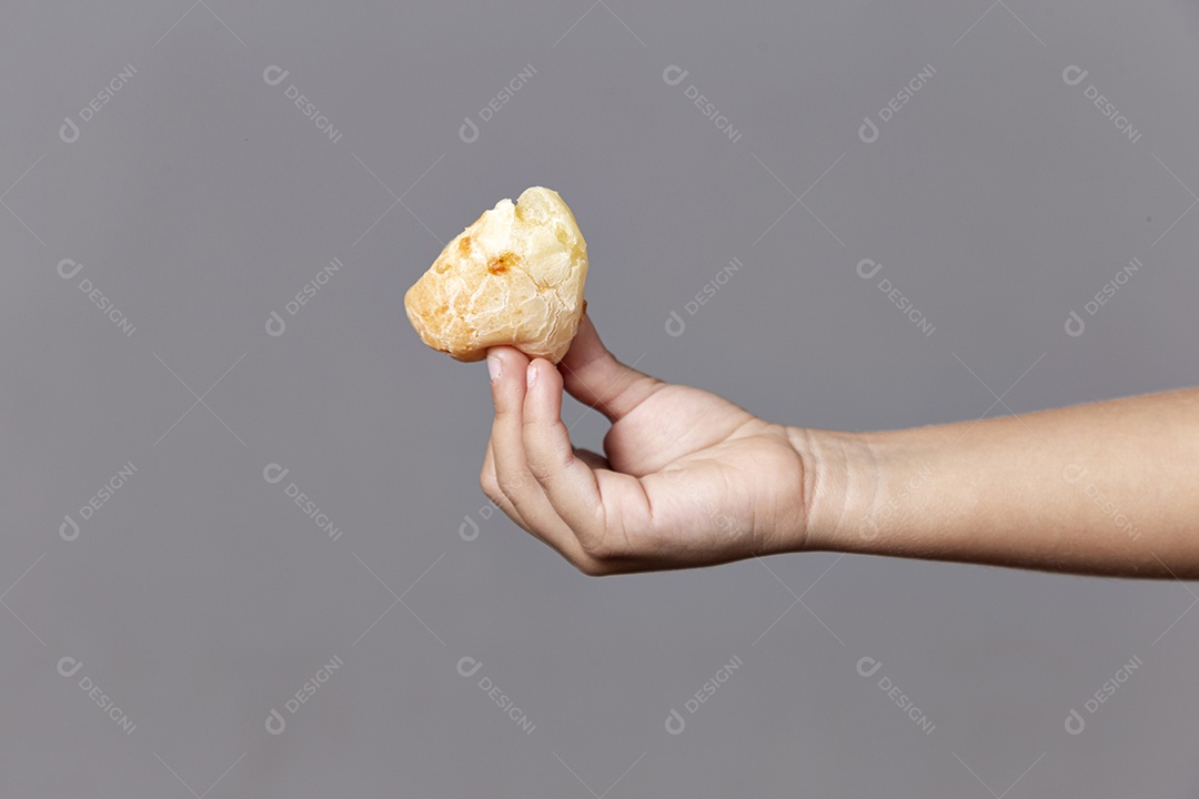 Mãos de pessoa segurando pão de queijo