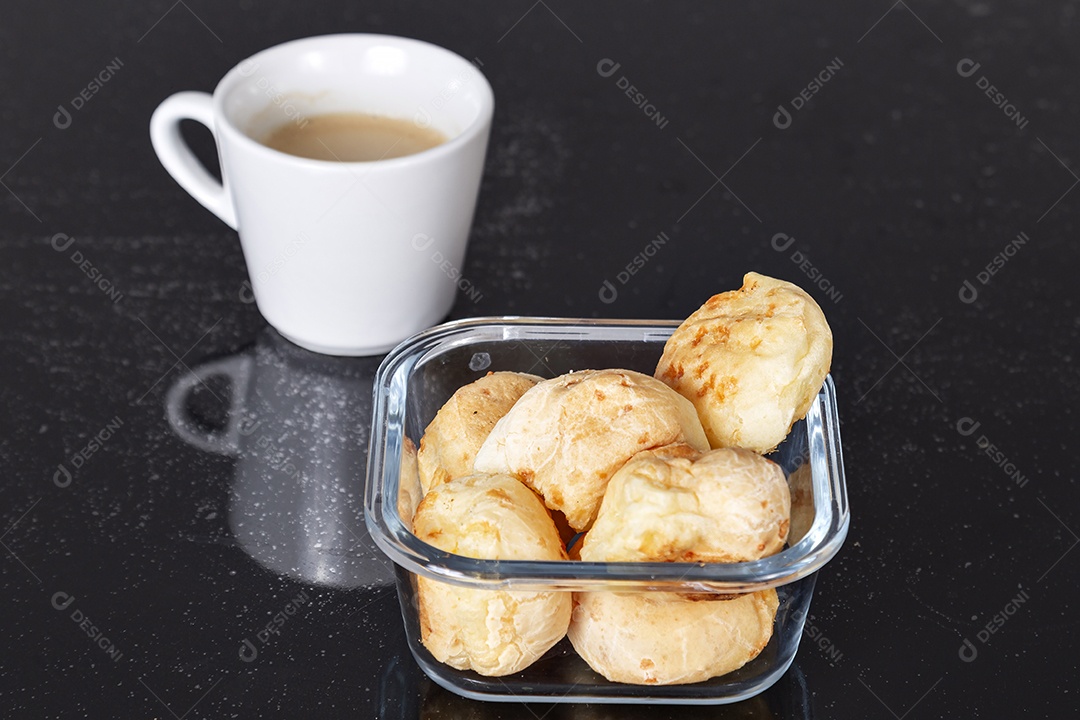 Tigela de pães e xicara de café sobre uma mesa escura