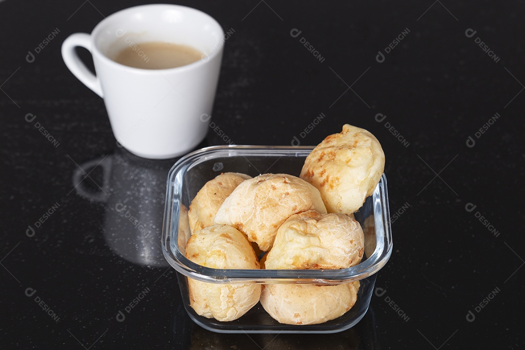 Tigela de pães e xicara de café sobre uma mesa escura