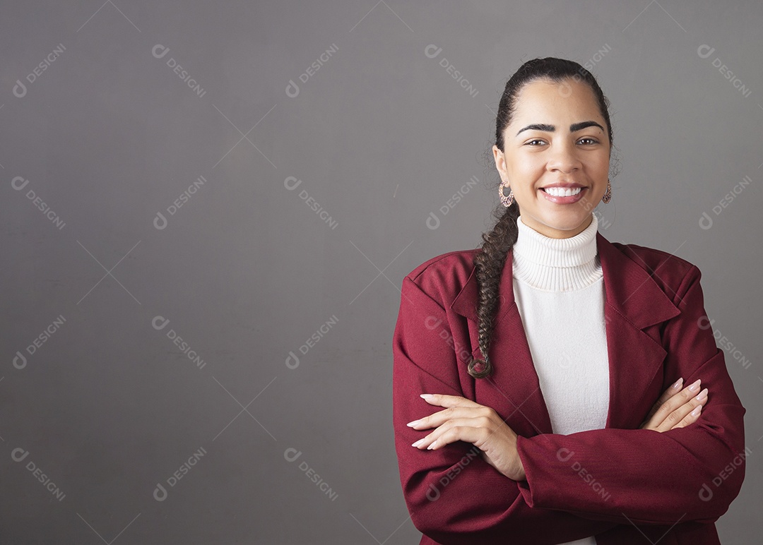 Linda mulher sorridente de braços cruzados vestida no bleizer sobre fundo isolado