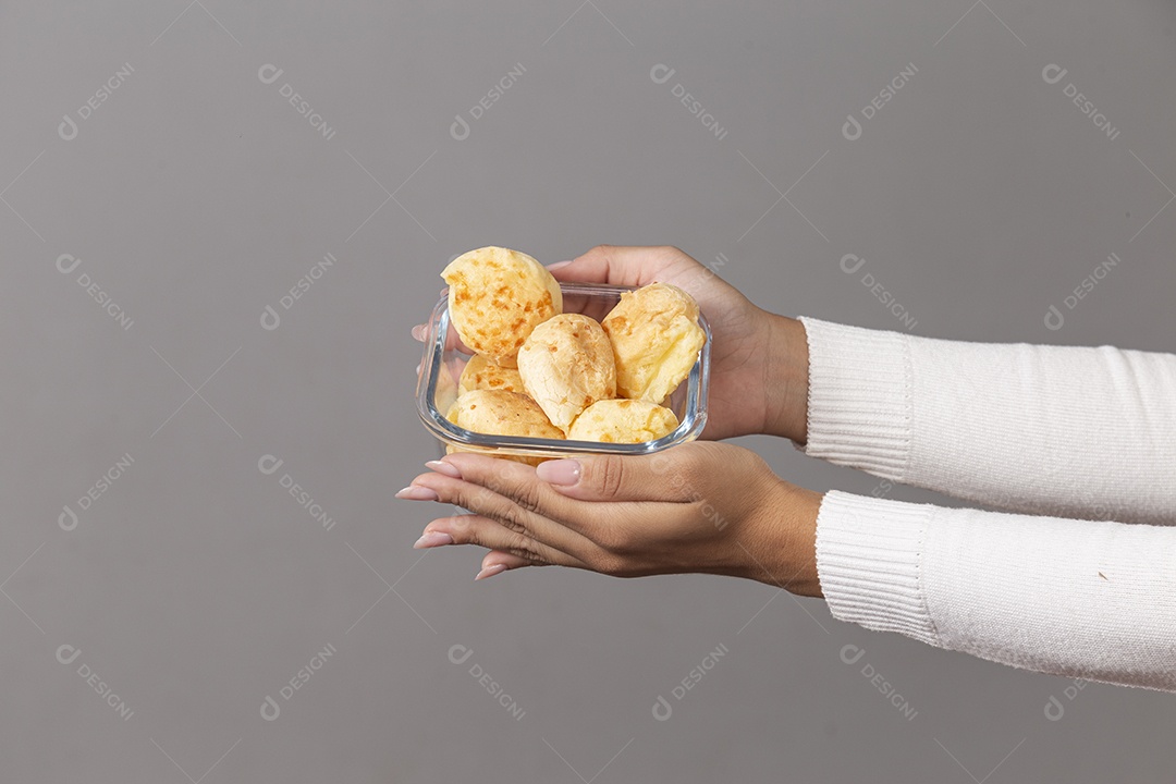 Mãos femininas segurando tigela com pães sobre fundo isolado