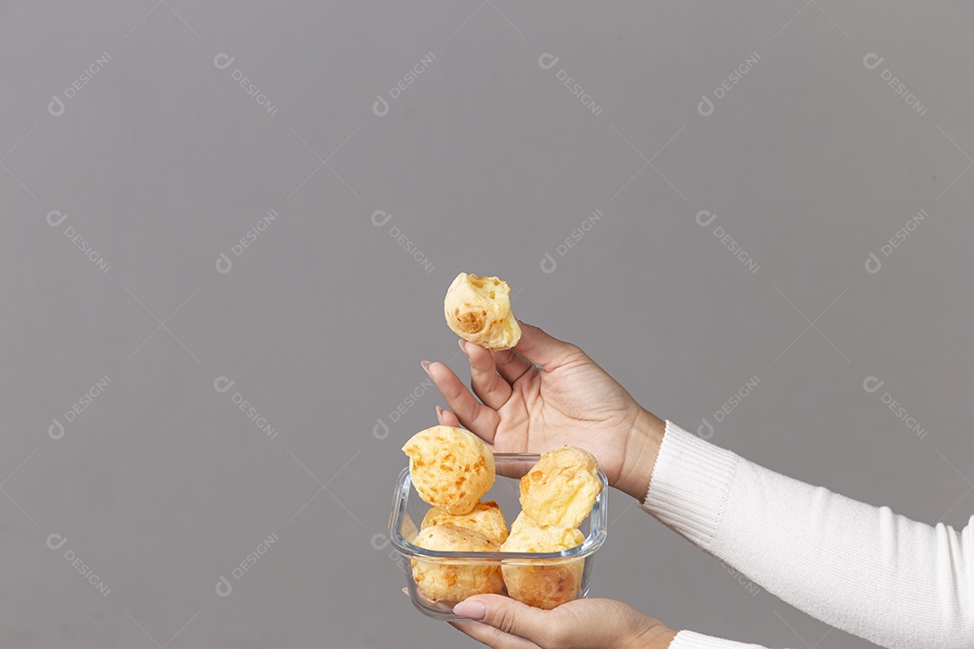 Mãos segurando tigela com pães sobre fundo isolado