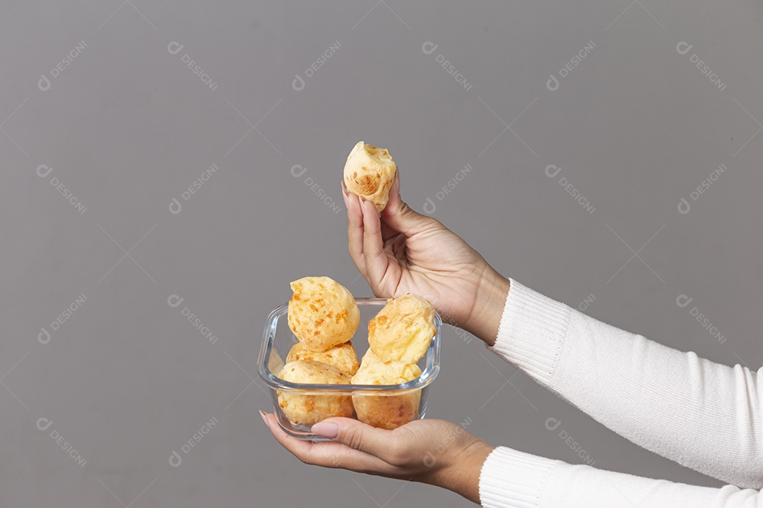 Mãos segurando tigela com pães sobre fundo isolado