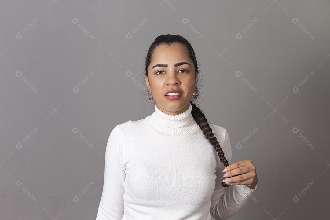 Jovem mulher segurando cabelo amarrado sobre fundo isolado