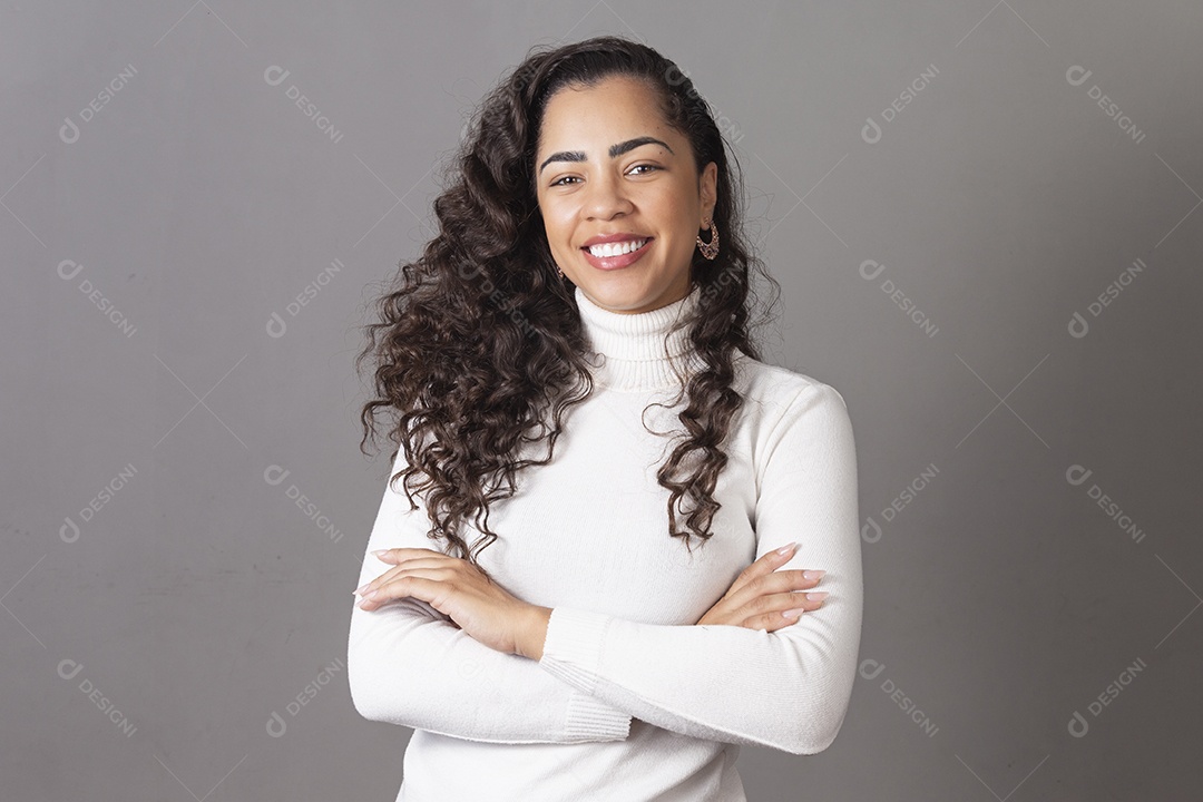 Linda mulher de cabelo cacheado com braços cruzados sobre fundo isolado
