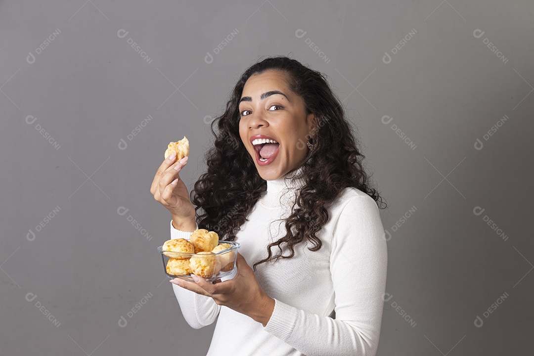 Jovem mulher sorridente comendo pão sobre fundo isolado