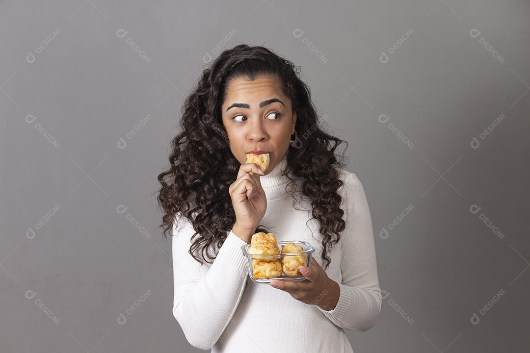 Mulher jovem comendo pão sobre fundo isolado