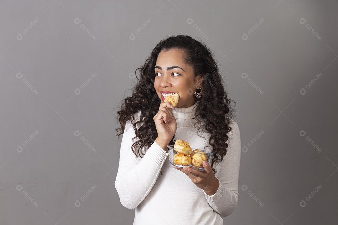 Mulher jovem comendo pães sobre fundo isolado