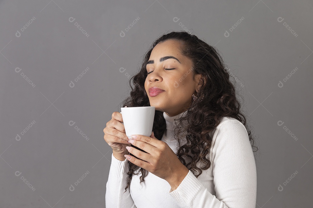 Linda mulher tomando cafe em uma xícara branca sobre fundo isoaldo.