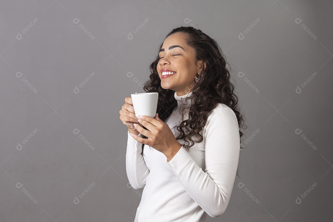 Linda mulher tomando cafe em uma xícara branca sobre fundo isoaldo.