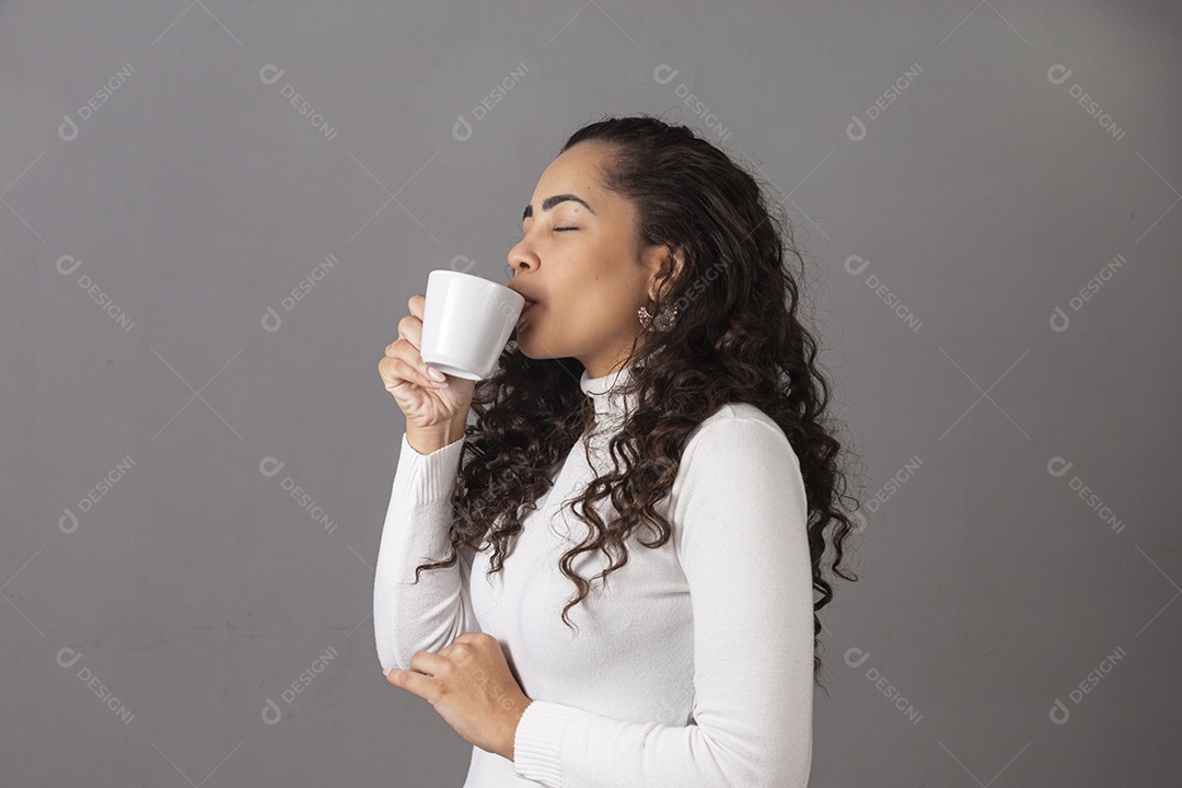 Linda mulher tomando cafe em uma xícara branca sobre fundo isoaldo.