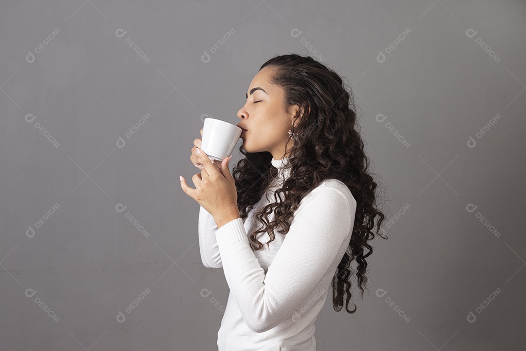 Linda mulher tomando cafe em uma xícara branca sobre fundo isoaldo.