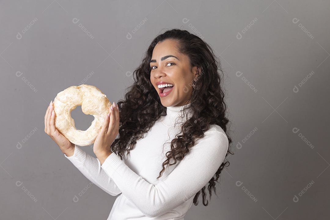 Linda mulher sorridente segurando biscoito de polvilho sobre fundo isolado