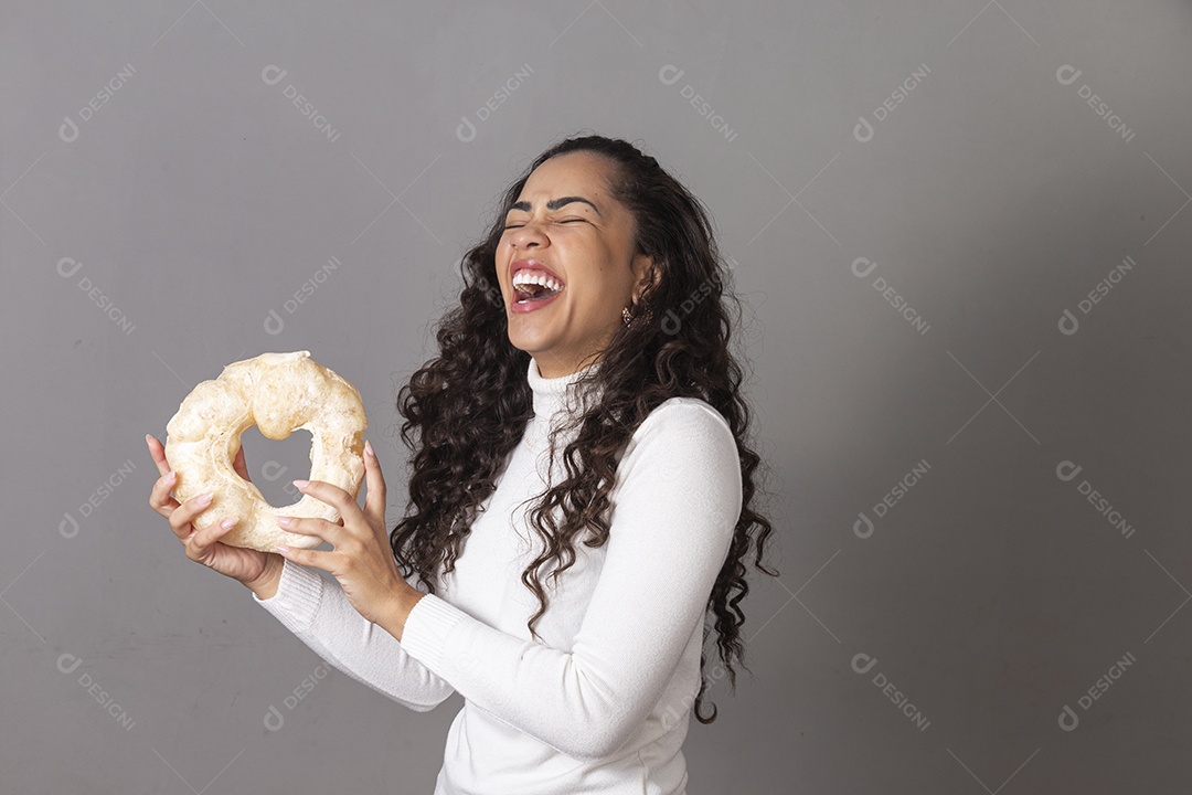 Linda mulher sorridente segurando biscoito de polvilho sobre fundo isolado