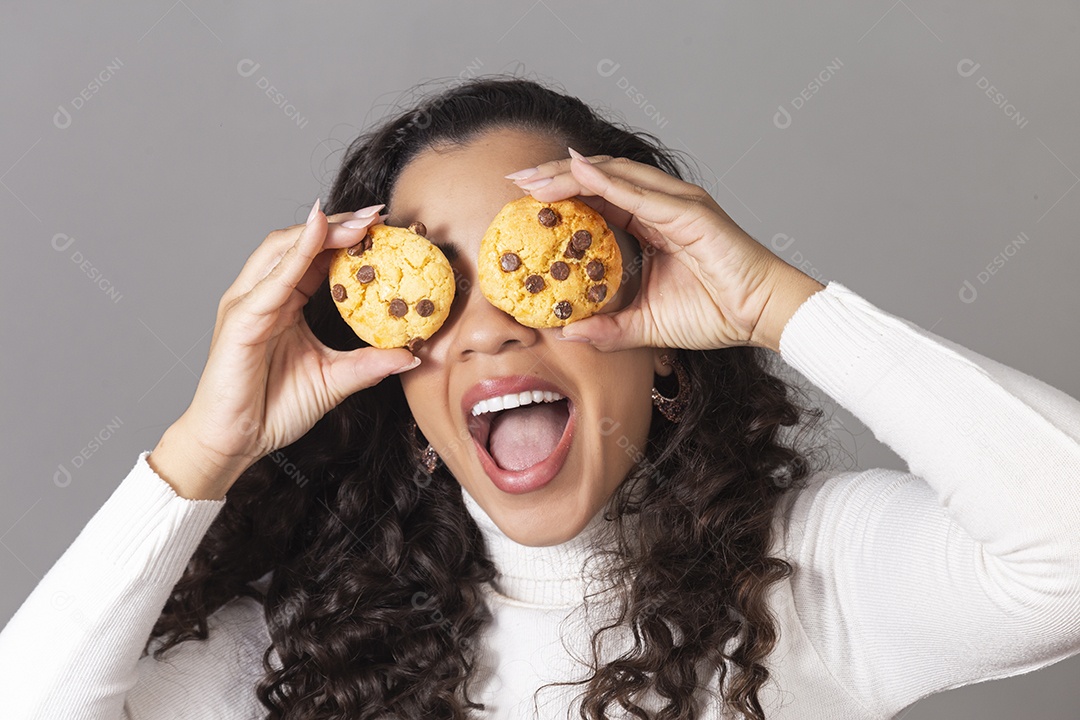 Linda mulher segurando biscoito sobre fundo isolado.