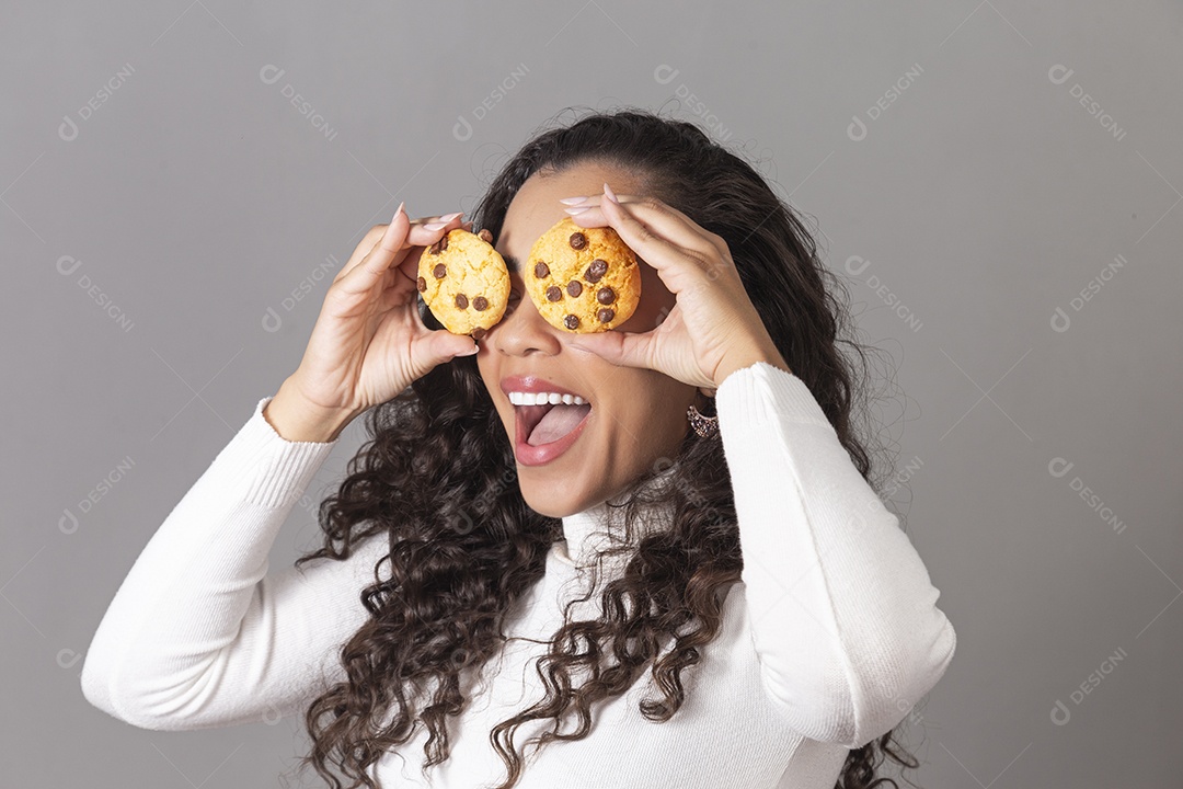 Linda jovem mulher segurando cookies sobre os olhos