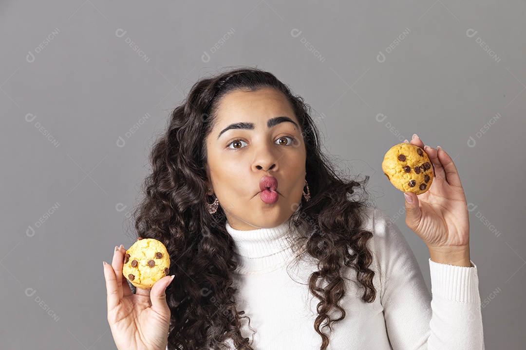 Linda munlher segurando biscoto sobre fundo isolado