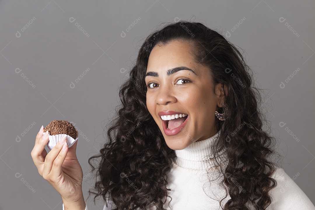 Linda mulher sorridente segurando um cupcake sobre fundo isolado.