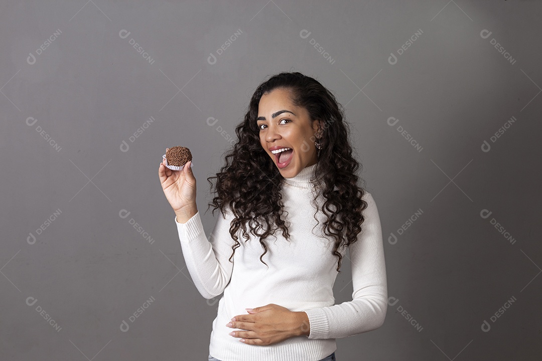 Linda mulher sorridente segurando bolo de forminha sobre fundo isolado.