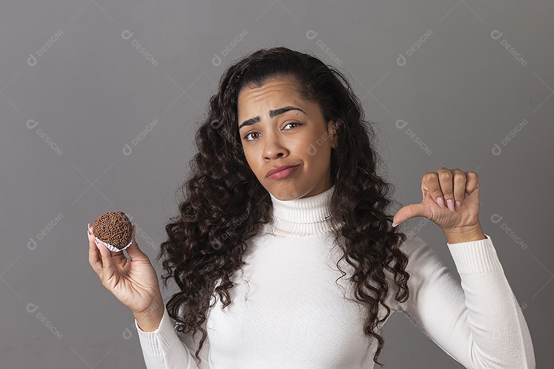 Linda mulher fazendo sinal negativo segurando um cupcake sobre fundo isolado