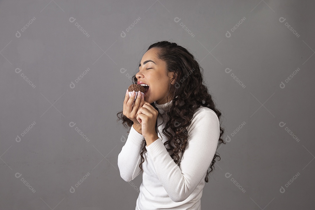 Linda mulher de cabelo cacheado se alimentando sobre um fundo isolado