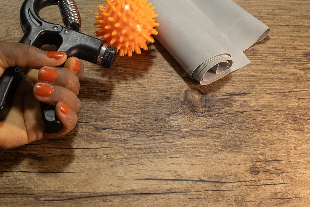 Aperto de mão para exercícios de pulso e cotovelo em uma mesa de madeira