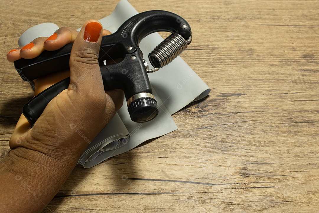 Aperto de mão para exercícios de pulso e cotovelo em uma mesa de madeira