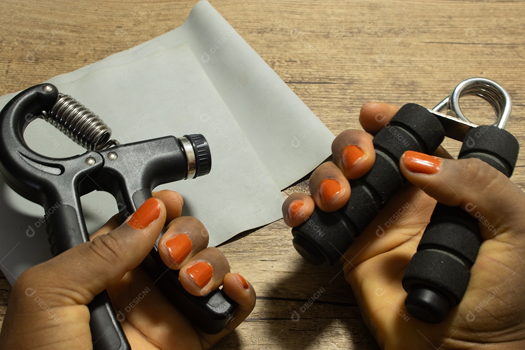 Aperto de mão para exercícios de pulso e cotovelo em uma mesa de madeira