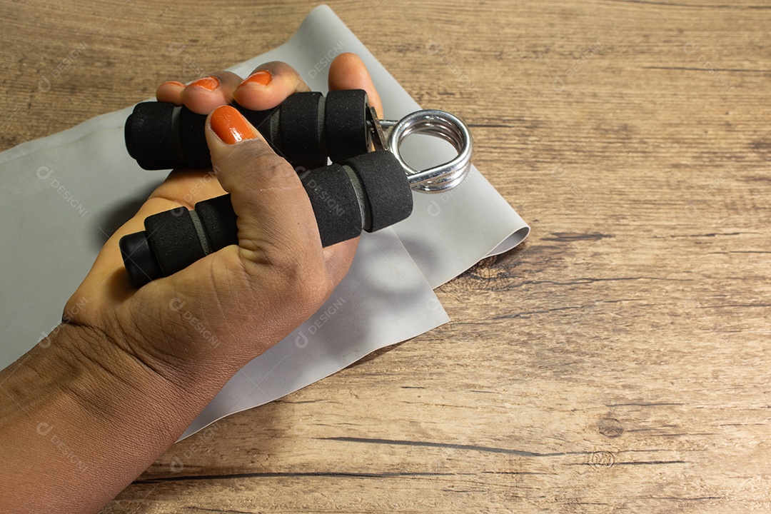 Aperto de mão para exercícios de pulso e cotovelo em uma mesa de madeira