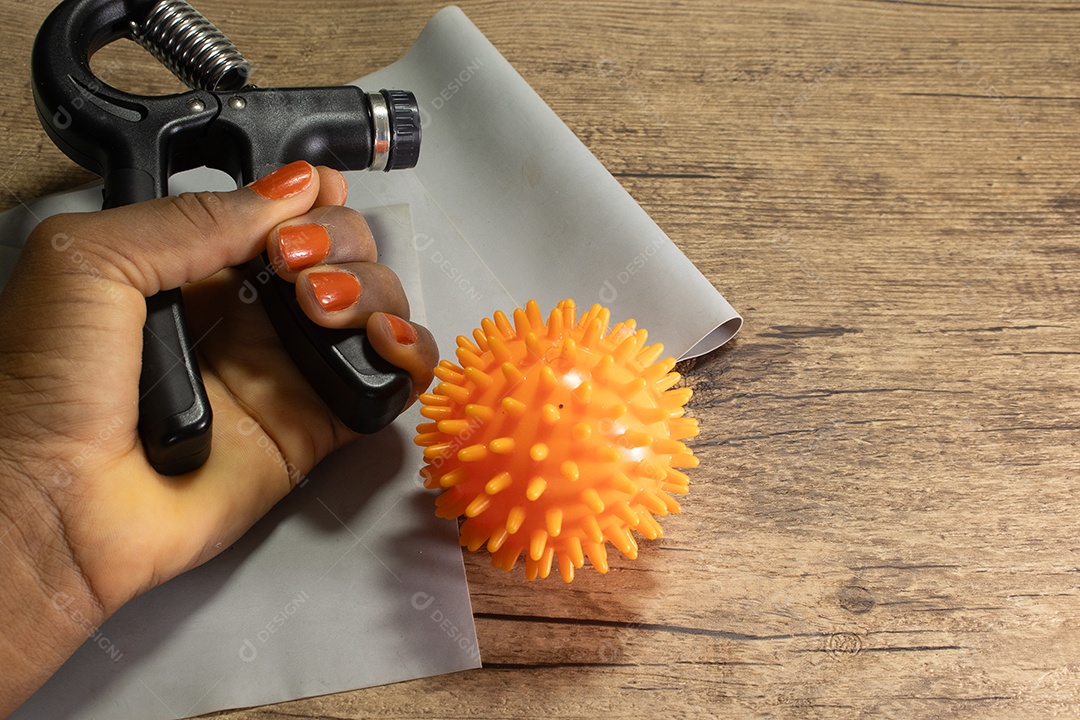 Aperto de mão para exercícios de pulso e cotovelo em uma mesa de madeira