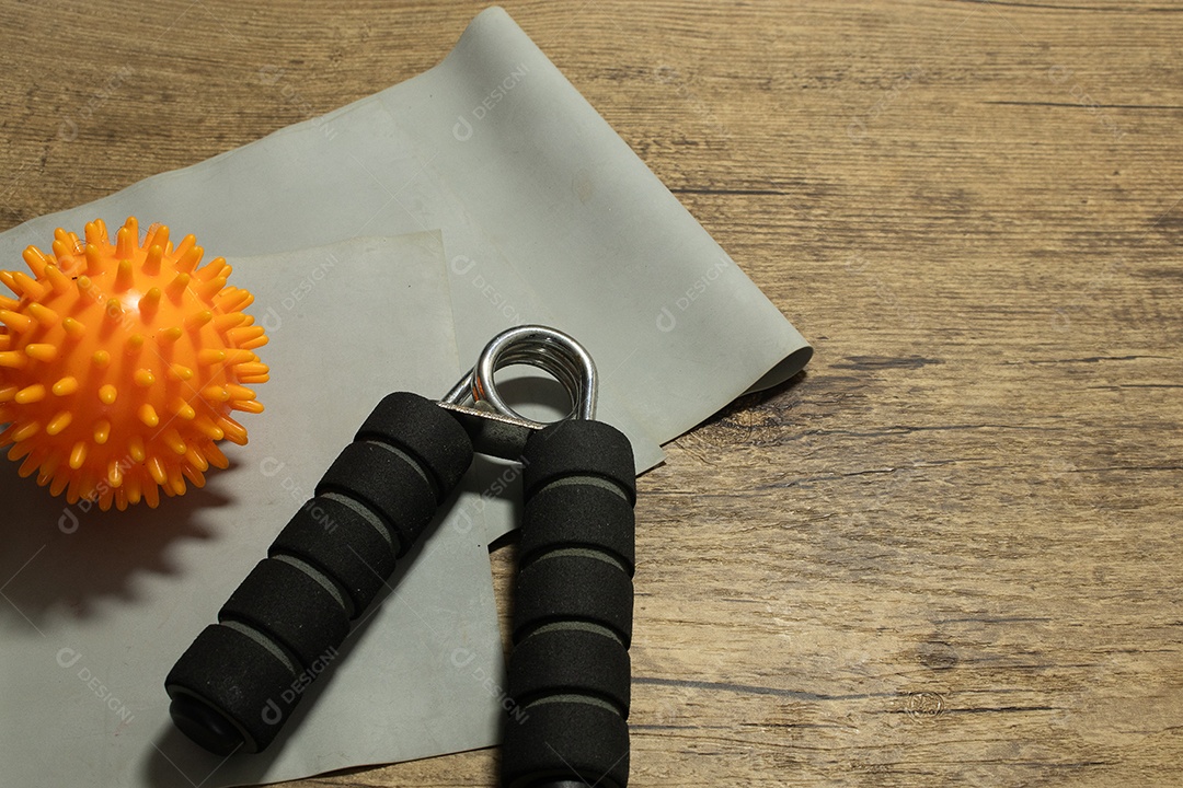 Aperto de mão para exercícios de pulso e cotovelo em uma mesa de madeira