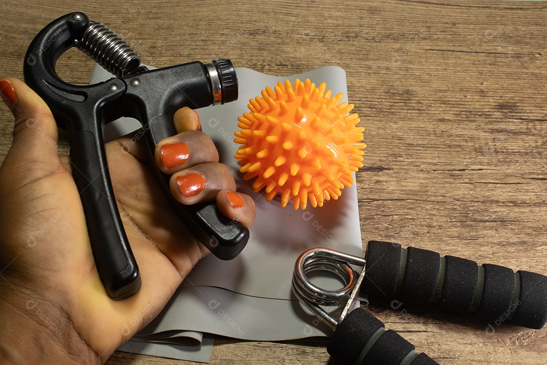 Aperto de mão para exercícios de pulso e cotovelo em uma mesa de madeira