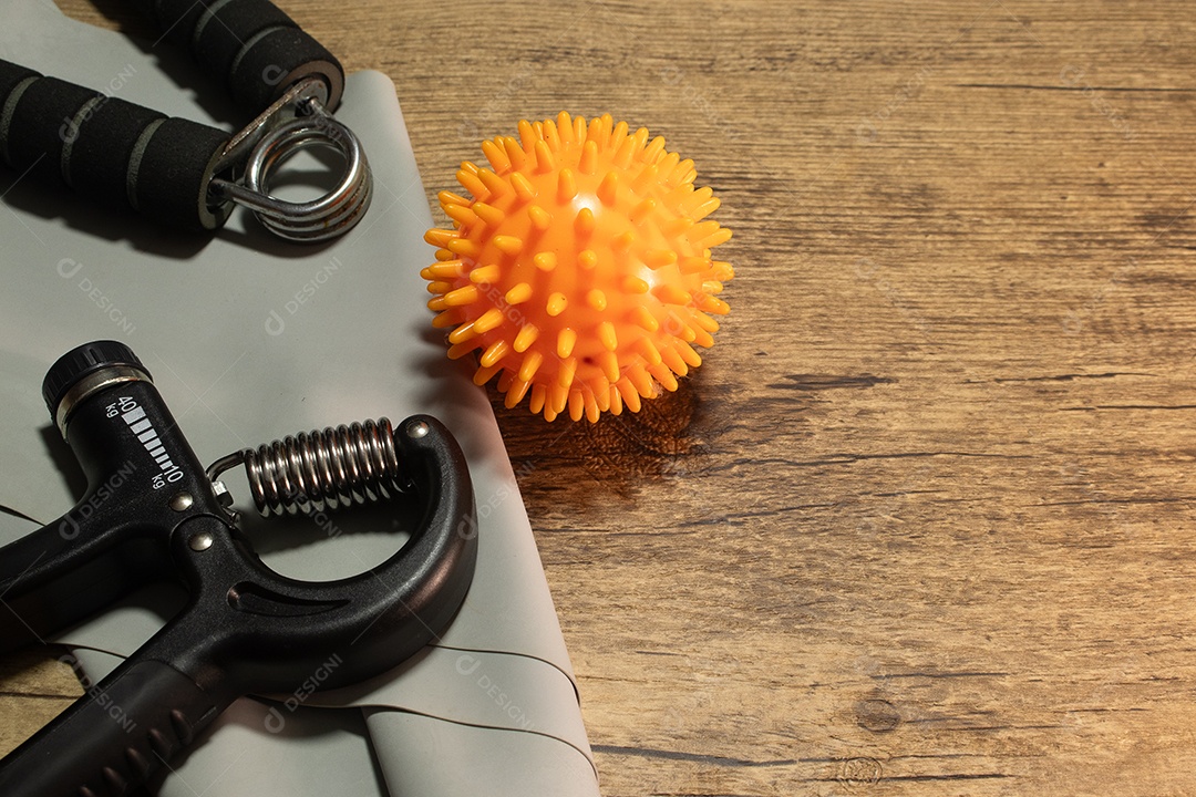 Aperto de mão para exercícios de pulso e cotovelo em uma mesa de madeira