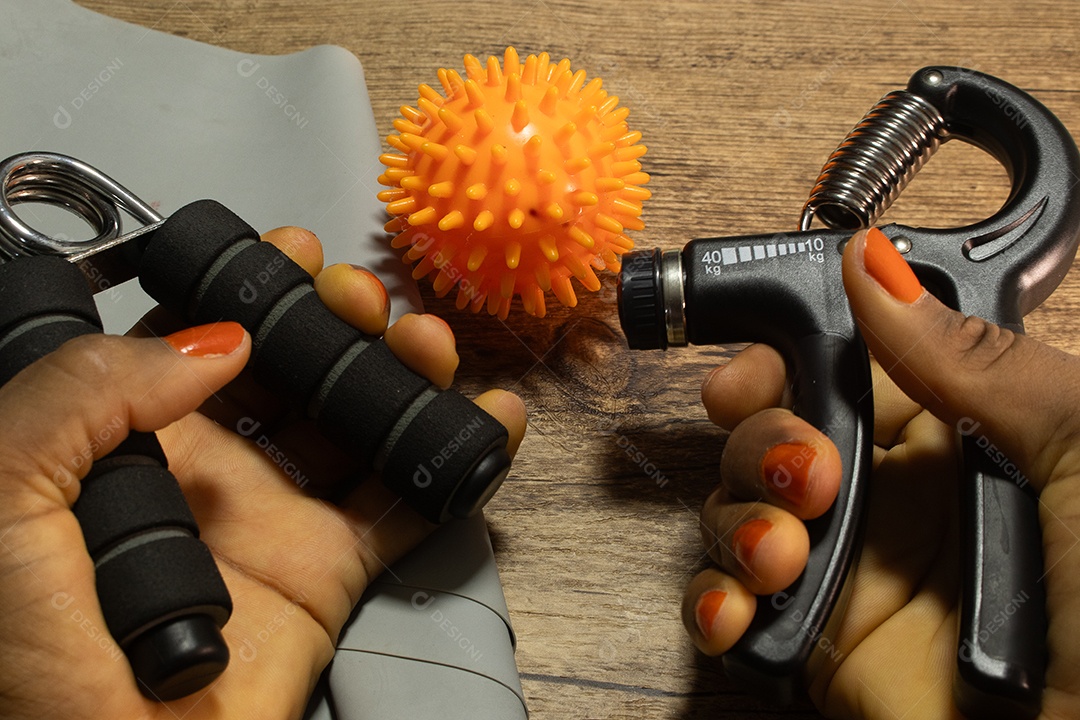 Aperto de mão para exercícios de pulso e cotovelo em uma mesa de madeira